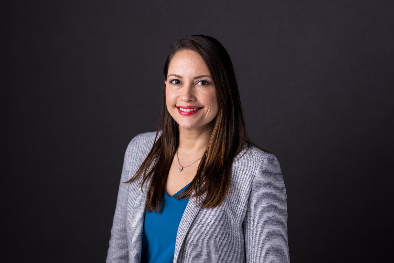 Headshot of a women in a black and blue blazer outfit. Julissa Cruz, Chicago IL